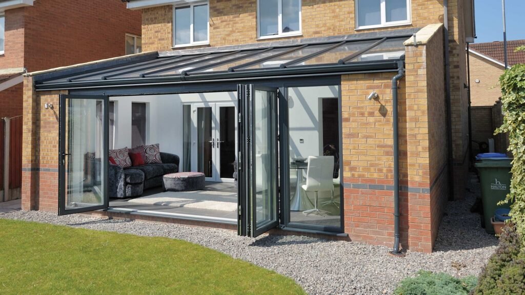 Conservatory with brick walls and black-framed glass doors in Poynton, Stockport, built by RT Joinery